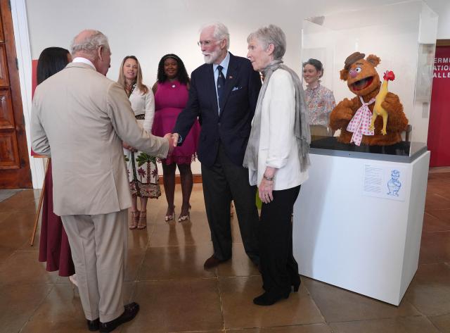 Britain's King Charles III (L) meets Bermuda-born Michael Frith (C), designer of the Muppets, Fraggle Rock and Dr. Seuss, and his wife Kathryn Mullen (R), at the City Hall and Arts Centre, on May 1, 2026 in Hamilton, Bermuda. King Charles III is in Bermuda for his first visit to a British Overseas Territory as Sovereign. (Photo by Yui Mok / POOL / AFP)