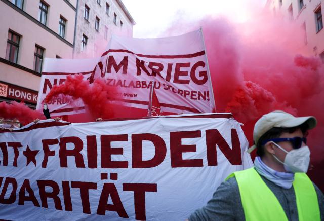 Demonstrators burn smoke bombs as they march with banners against war and for peace, solidarity and freedom during the annual leftist May Day demonstration in Berlin's Kreuzberg district on May 1, 2026. (Photo by Odd ANDERSEN / AFP)