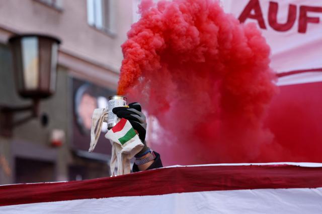 A demonstrator holds up a smoke bomb container during the annual leftist May Day demonstration in Berlin's Kreuzberg district on May 1, 2026. (Photo by Odd ANDERSEN / AFP)
