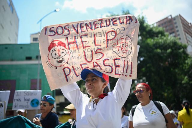 Demonstrators take part in a protest demanding better working conditions and pensions during a May Day rally marking International Workers Day, in Caracas, on May 1, 2026. (Photo by Federico PARRA / AFP)