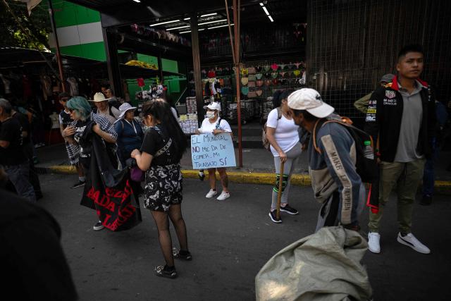 A sex worker holds a sign reading "The World Cup does not feed me, my work does" as she protests for better working conditions amid restrictions linked to the upcoming FIFA 2026 World Cup imposed by the Mexican government, in Mexico City, on International Workers Day, on May 1, 2026. (Photo by CARL DE SOUZA / AFP)