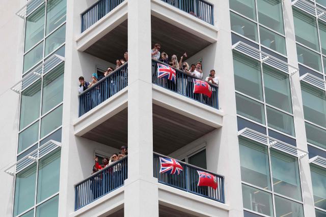 People look from the balconies as Britain's King Charles visits Hamilton, Bermuda, on May 1, 2026. King Charles III is in Bermuda for his first visit to a British Overseas Territory as Sovereign. (Photo by Suzanne Plunkett / POOL / AFP)