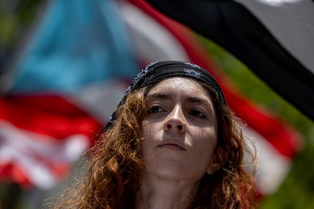 A woman march as people take part in a May Day rally marking International Workers' Day in San Juan, Puerto Rico on May 1, 2026. (Photo by Ricardo ARDUENGO / AFP)