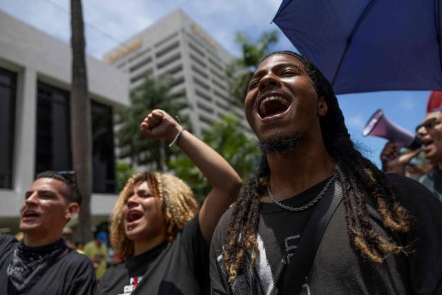 Demonstrators shout slogans as they take part in a May Day rally marking International Workers' Day in San Juan, Puerto Rico on May 1, 2026. (Photo by Ricardo ARDUENGO / AFP)