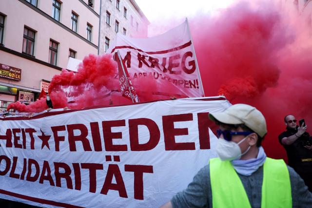 Demonstrators burn smoke bombs as they march with banners against war and for peace, solidarity and freedom during the annual leftist May Day demonstration in Berlin's Kreuzberg district on May 1, 2026. (Photo by Odd ANDERSEN / AFP)