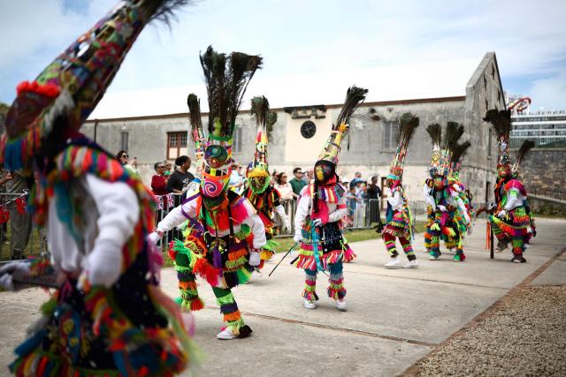 Gombey dancers perform during a cultural welcome for Britain's King Charles III at the Royal Naval Dockyard, Sandys Parish, Bermuda on May 1, 2026. King Charles III is in Bermuda for his first visit to a British Overseas Territory as Sovereign. (Photo by HENRY NICHOLLS / AFP)