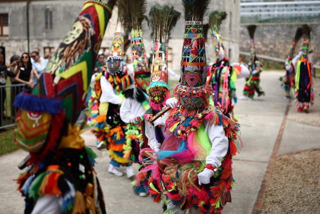 Gombey dancers perform during a cultural welcome for Britain's King Charles III at the Royal Naval Dockyard, Sandys Parish, Bermuda on May 1, 2026. King Charles III is in Bermuda for his first visit to a British Overseas Territory as Sovereign. (Photo by HENRY NICHOLLS / AFP)
