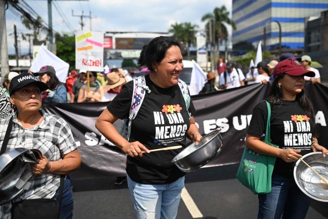 Women bang pots and pans as they take part in a march marking International Workers' Day in San Salvador on May 1, 2026. (Photo by MARVIN RECINOS / AFP)