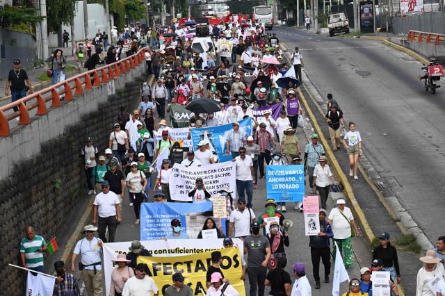 People take part in a march against the government marking International Workers' Day in San Salvador on May 1, 2026. (Photo by MARVIN RECINOS / AFP)