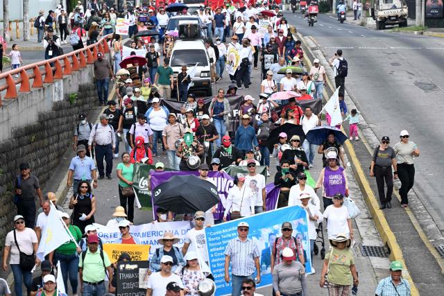 People take part in a march against the government marking International Workers' Day in San Salvador on May 1, 2026. (Photo by MARVIN RECINOS / AFP)