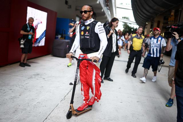 Ferrari's British driver Lewis Hamilton rides a scooter as he makes his way to his garage before the start of Sprint qualifying ahead of the 2026 Miami Formula One Grand Prix at Miami International Autodrome in Miami Gardens, Florida, on May 1, 2026. (Photo by CHARLY TRIBALLEAU / AFP)