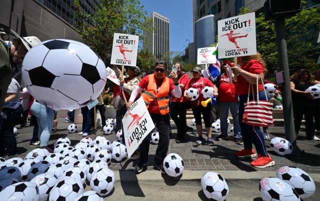 People play with inflatable footballs during a May Day rally marking International Workers' Day in Los Angeles, on May 1, 2026. (Photo by Frederic J. BROWN / AFP)