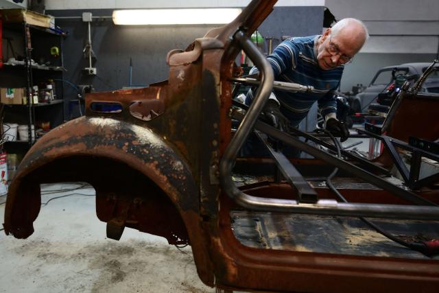 A worker operates on an old Fiat 500 model that will be transformed into an electric 500 Jolly Lido model at the Officine Gentile garage in Turin on April 30, 2026. In the Officine Gentile workshop in Turin -- the historic home of Italian carmaker Fiat -- vintage 500 models are getting a makeover with electric engines. The original Fiat 500 became a design icon and some 4.2 million models were made. The retrofitted cars sell for around 40-50,000 euros with convertibles for up to 80,000 euros. (Photo by MARCO BERTORELLO / AFP)