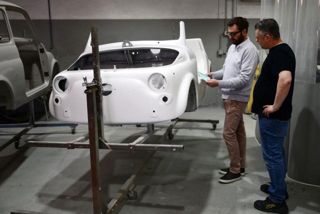 Owner of the Officine Gentile garage, Giovanni Gentile (R) and marketing manager Giorgio Pagliero decide on the color of a Fiat 500 model that will be transformed into an electric 500 Jolly Lido model at Officine Gentile in Turin on April 30, 2026. In the Officine Gentile workshop in Turin -- the historic home of Italian carmaker Fiat -- vintage 500 models are getting a makeover with electric engines. The original Fiat 500 became a design icon and some 4.2 million models were made. The retrofitted cars sell for around 40-50,000 euros with convertibles for up to 80,000 euros. (Photo by MARCO BERTORELLO / AFP)