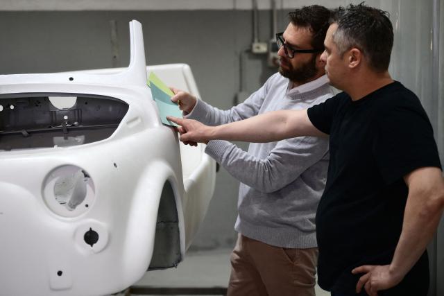 Owner of the Officine Gentile garage, Giovanni Gentile (R) and marketing manager Giorgio Pagliero decide on the color of a Fiat 500 model that will be transformed into an electric 500 Jolly Lido model at Officine Gentile in Turin on April 30, 2026.. In the Officine Gentile workshop in Turin -- the historic home of Italian carmaker Fiat -- vintage 500 models are getting a makeover with electric engines. The original Fiat 500 became a design icon and some 4.2 million models were made. The retrofitted cars sell for around 40-50,000 euros with convertibles for up to 80,000 euros. (Photo by MARCO BERTORELLO / AFP)