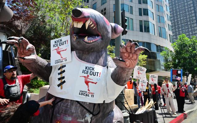"Kick ICE Out" signs are placed on an infaltable rat as SOFI stadium workers protest outside FIFA World Cup 26 Los Angeles Office calling for ICE to be banned from the World Cup on May 1, 2026. Eight World Cup matches are planned for SOFI stadium during this summer's World Cup. (Photo by Frederic J. BROWN / AFP)