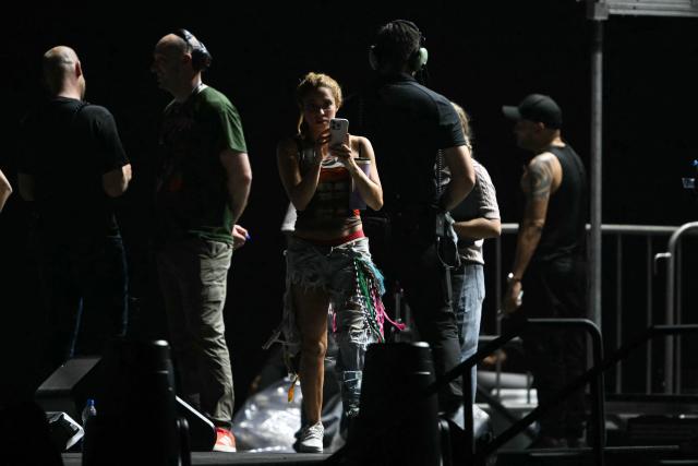 Colombian singer Shakira (C) uses a mobile phone during a rehearsal at Copacabana Beach in Rio de Janeiro, Brazil on May 1, 2026. The Colombian singer is scheduled to perform on May 2. (Photo by Mauro PIMENTEL / AFP)