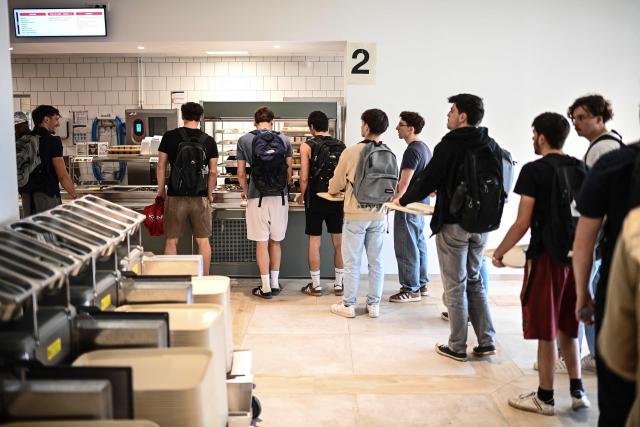 (FILES) Students queue up for their meal at a CROUS (Centre Regional des Oeuvres Universitaires et Scolaires) university restaurant at the Bordeaux University in Talence, south-western France, on April 24, 2026. From May 4, 2026, all students, regardless of their income, will be able to eat in university canteens for just one euro – a measure called for by student organisations and included in the 2026 budget as a concession by the government to Socialist MPs.
The one-euro meal in canteens run by the Regional Centres for University and School Services (Crous) already exists for students on grants and those in financial difficulty. Until now, other students have been paying 3.30 euros – they had temporarily benefited from one-euro meals during the Covid pandemic. (Photo by Christophe ARCHAMBAULT / AFP)