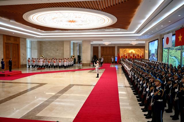 Vietnam's Prime Minister Le Minh Hung (L) and Japan's Prime Minister Sanae Takaichi (2nd L) review a guard of honour during a welcoming ceremony at the Government Office in Hanoi on May 2, 2026. (Photo by Nhac NGUYEN / POOL / AFP)
