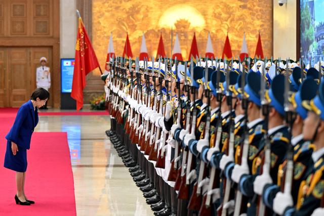 Japan's Prime Minister Sanae Takaichi review a guard of honour during a welcoming ceremony at the Government Office in Hanoi on May 2, 2026. (Photo by Nhac NGUYEN / POOL / AFP)