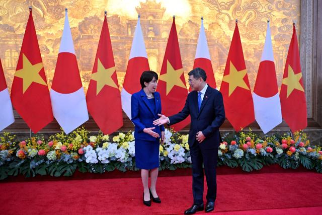 Vietnam's Prime Minister Le Minh Hung (R) greets Japan's Prime Minister Sanae Takaichi (L) at the Government Office in Hanoi on May 2, 2026. (Photo by Nhac NGUYEN / POOL / AFP)