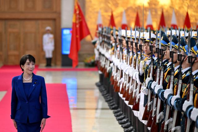 Japan's Prime Minister Sanae Takaichi reviews a guard of honour during a welcoming ceremony at the Government Office in Hanoi on May 2, 2026. (Photo by Nhac NGUYEN / POOL / AFP)