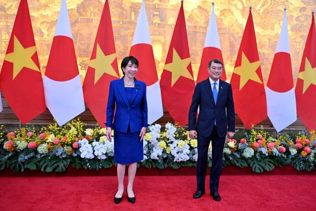 Vietnam's Prime Minister Le Minh Hung (R) and Japan's Prime Minister Sanae Takaichi (L) stand during a welcoming ceremony at the Government Office in Hanoi on May 2, 2026. (Photo by Nhac NGUYEN / POOL / AFP)