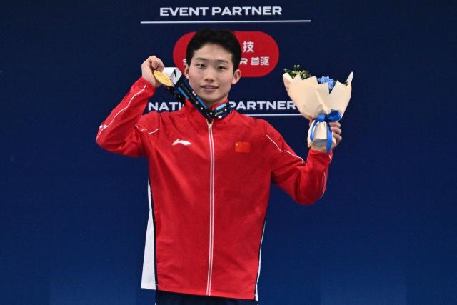 China’s Wang Zongyuan celebrates on the podium after winning the men’s 3 meter springboard event at the World Aquatics Diving World Cup Super Final, in the Water Cube in Beijing on May 2, 2026. (Photo by Pedro PARDO / AFP)