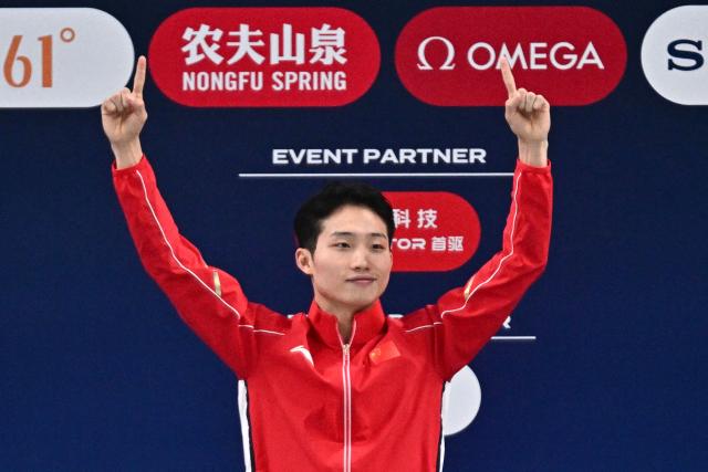 China’s Wang Zongyuan celebrates on the podium after winning the men’s 3 meter springboard event at the World Aquatics Diving World Cup Super Final, in the Water Cube in Beijing on May 2, 2026. (Photo by Pedro PARDO / AFP)