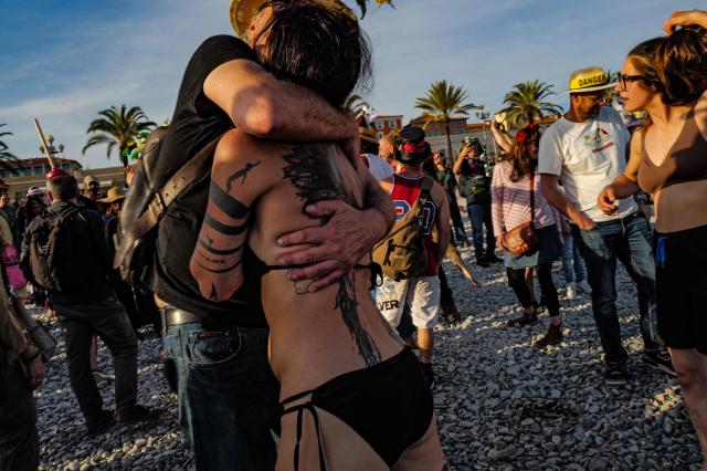 Revelers participate at the traditional "Santa Capelina" festival in Nice, south-eastern France, on May 1, 2026. Revelers gather on May 1 in Nice to celebrate the annual Santa Capelina, parading in hand-made hats and sharing a fish soup cooked on site, with each participant contributing their own fish. A Santa figure, built collectively from branches and flowers with a papier-mâché head, is carried in a procession to the beach before casting it into the sea. (Photo by Valery HACHE / AFP)