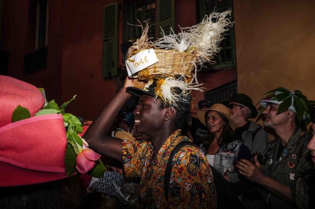 Revelers participate at the traditional "Santa Capelina" festival in Nice, south-eastern France, on May 1, 2026. Revelers gather on May 1 in Nice to celebrate the annual Santa Capelina, parading in hand-made hats and sharing a fish soup cooked on site, with each participant contributing their own fish. A Santa figure, built collectively from branches and flowers with a papier-mâché head, is carried in a procession to the beach before casting it into the sea. (Photo by Valery HACHE / AFP)