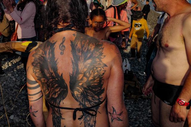 Revelers participate at the traditional "Santa Capelina" festival in Nice, south-eastern France, on May 1, 2026. Revelers gather on May 1 in Nice to celebrate the annual Santa Capelina, parading in hand-made hats and sharing a fish soup cooked on site, with each participant contributing their own fish. A Santa figure, built collectively from branches and flowers with a papier-mâché head, is carried in a procession to the beach before casting it into the sea. (Photo by Valery HACHE / AFP)