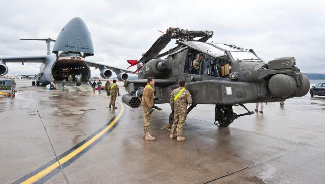 (FILES) An AH-64 Apache attack helicopter stands in front of a Galaxy C-5 transport plane at the US Air Base in Ramstein, western Germany, on February 22, 2017. Germany's defence minister on May 2, 2026, said the withdrawal of American troops from Germany had been expected and that Europe needed to do more to ensure its own security. The Pentagon on May 1, announced the withdrawal of about 5,000 troops from Germany within the next year, the latest rift in transatlantic ties over the Mideast war. (Photo by Martin GOLDHAHN / dpa / AFP) / Germany OUT