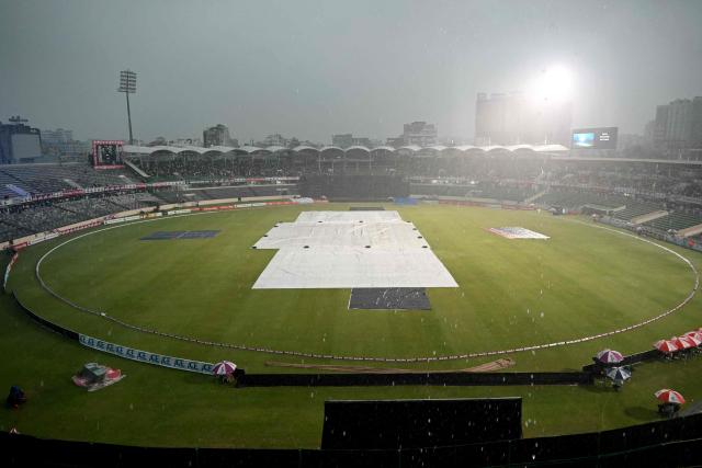 The pitch remains covered as rain halts play during the third T20 cricket match between Bangladesh and New Zealand at the Sher-e-Bangla National Stadium in Mirpur on May 2, 2026. (Photo by Munir UZ ZAMAN / AFP)