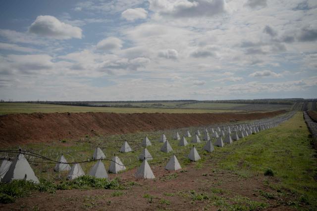 This photograph shows dragon's teeth, pyramidal anti-tank obstacles of reinforced concrete, and a barbed wire defence line at an undisclosed location in the Kharkiv region, eastern Ukraine, on May 1, 2026, amid the Russian invasion of Ukraine. (Photo by Ivan SAMOILOV / AFP)