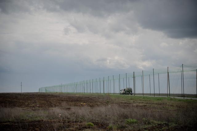 A vehicle drives on a road covered with anti-drone nets in the Kharkiv region on May 1, 2026, amid the Russian invasion of Ukraine. (Photo by Ivan SAMOILOV / AFP)