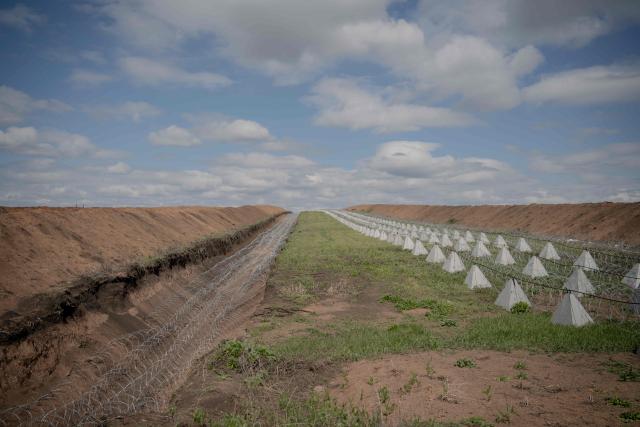 This photograph shows dragon's teeth, pyramidal anti-tank obstacles of reinforced concrete, and a barbed wire defence line at an undisclosed location in the Kharkiv region, eastern Ukraine, on May 1, 2026, amid the Russian invasion of Ukraine. (Photo by Ivan SAMOILOV / AFP)