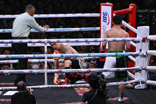 Kazuto Ioka (L) falls to the mat after being knocked down by Takuma Inoue during their WBC Bantamweight Title Match boxing contest at Tokyo Dome in Tokyo on May 2, 2026. (Photo by Yuichi YAMAZAKI / AFP)