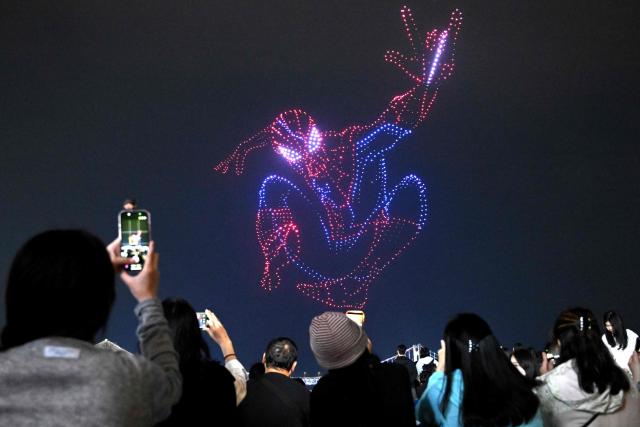 A swarm of 1,500 drones forms the shape of Spider-Man in the night sky above Gwangan Bridge during a drone light show to promote the movie "Spider-Man: Brand New Day" at Gwangalli Beach in Busan on May 2, 2026. (Photo by Jung Yeon-je / AFP)