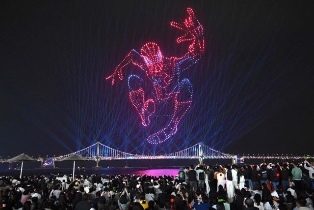 A swarm of 1,500 drones forms the shape of Spider-Man in the night sky above Gwangan Bridge during a drone light show to promote the movie "Spider-Man: Brand New Day" at Gwangalli Beach in Busan on May 2, 2026. (Photo by Jung Yeon-je / AFP)