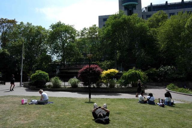 People enjoy the sunshine whilst sitting in Victoria Gardens in central London on May 2, 2026. (Photo by CARLOS JASSO / AFP)