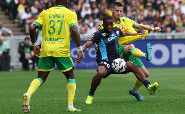 Nantes' Cameroonian forward #37 Ignatius Ganago and Nantes' French defender #24 Frederic Guilbert (R) fight for the ball with Marseille's Ivorian midfielder #20 Hamed Junior Traore during the French L1 football match between FC Nantes and Olympique de Marseille at the Stade de la Beaujoire–Louis Fonteneau in Nantes, western France on May 2, 2026. (Photo by Fred TANNEAU / AFP)