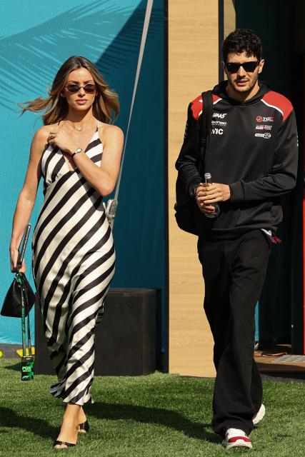 Haas F1 Team's French driver Esteban Ocon and French model Flavy Barla arrive for the 2026 Miami Formula One Sprint at Miami International Autodrome in Miami Gardens, Florida, on May 2, 2026. (Photo by CHARLY TRIBALLEAU / AFP)