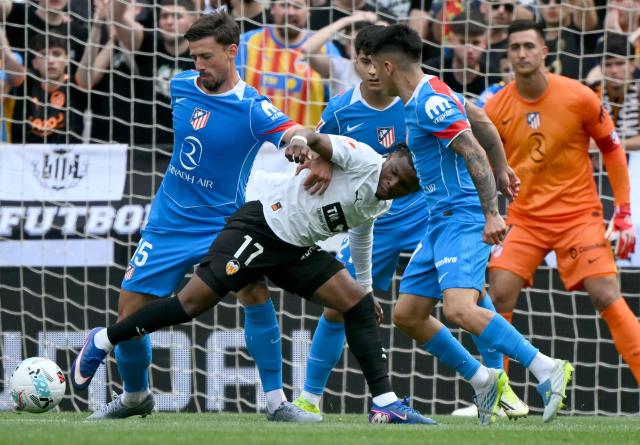 Valencia's Belgian forward # 17 Largie Ramazani fights for the ball with Atletico Madrid's French defender #15 Clement Lenglet during the Spanish league football match between Valencia CF and Club Atletico de Madrid at Mestalla Stadium in Valencia on May 2, 2026. (Photo by JOSE JORDAN / AFP)