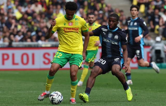 Nantes' Madagascan defender #22 Mathieu Acapandie fights for the ball with Marseille's Ivorian midfielder #20 Hamed Junior Traore during the French L1 football match between FC Nantes and Olympique de Marseille at the Stade de la Beaujoire–Louis Fonteneau in Nantes, western France on May 2, 2026. (Photo by Fred TANNEAU / AFP)