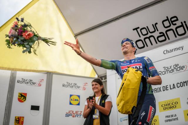 Soudal QuickStep’s Belgian rider Louis Vervaeke, awarded as best combative of the stage, throws flowers during the podium ceremony of the fourth stage of the Tour of Romandie UCI cycling World tour, 149.6 km from Broc and to Charmey, in Charmey, Switzerland, on May, 2, 2026. (Photo by Fabrice COFFRINI / AFP)