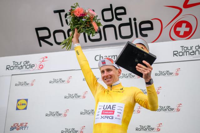 UAE Team Emirates-XRG's Slovenian rider Tadej Pogacar wearing the overall leader's yellow jersey celebrates during the podium ceremony after winning the fourth stage of the Tour of Romandie UCI cycling World tour, 149.6 km from Broc and to Charmey, in Charmey, Switzerland, on May, 2, 2026. (Photo by Fabrice COFFRINI / AFP)
