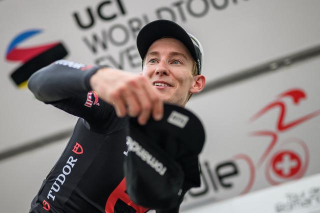 Tudor Pro Cycling Team’s Swiss rider Yannis Voisard, awarded as best Swiss of the race, throws a cap during the podium ceremony of the fourth stage of the Tour of Romandie UCI cycling World tour, 149.6 km from Broc and to Charmey, in Charmey, Switzerland, on May, 2, 2026. (Photo by Fabrice COFFRINI / AFP)