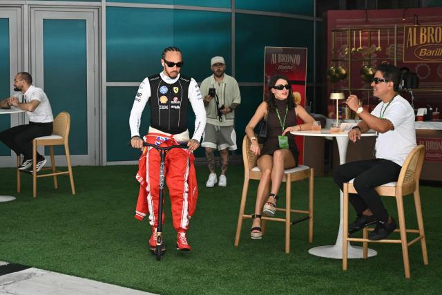 Ferrari's British driver Lewis Hamilton rides a scooter as he makes his way from the paddock to the garage ahead of the 2026 Miami Formula One Sprint at Miami International Autodrome in Miami Gardens, Florida, on May 2, 2026. (Photo by CHANDAN KHANNA / AFP)