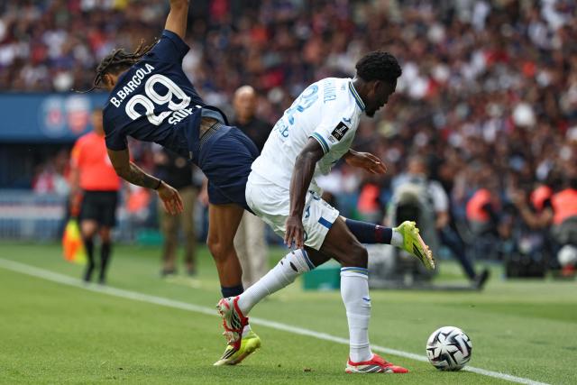 Paris Saint-Germain's French forward #29 Bradley Barcola (L) and Lorient's Ghanaian defender #32 Nathaniel Adjei (R) fight for the ball during the French L1 football match between Paris Saint-Germain (PSG) and FC Lorient at Parc des Princes stadium in Paris on May 2, 2026. (Photo by FRANCK FIFE / AFP)